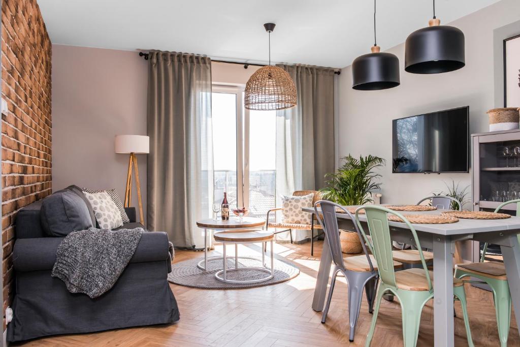 - un salon et une salle à manger avec une table et des chaises dans l'établissement Apartament przy Zachodnim, à Olsztyn