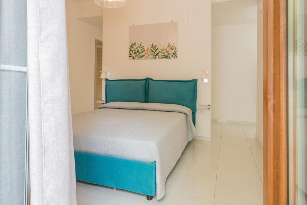 a bedroom with a blue and white bed in a room at La Casa Sul Corso in Santa Maria di Castellabate