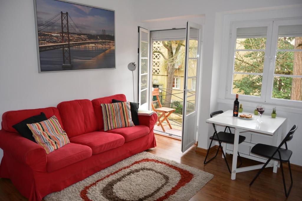 a living room with a red couch and a table at Charming Apartment to feel Lisbon in Lisbon