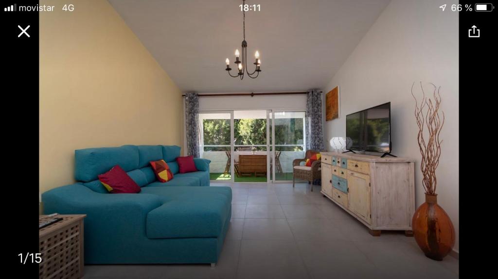 a living room with a blue couch and a tv at Central Chayofa in Chayofa