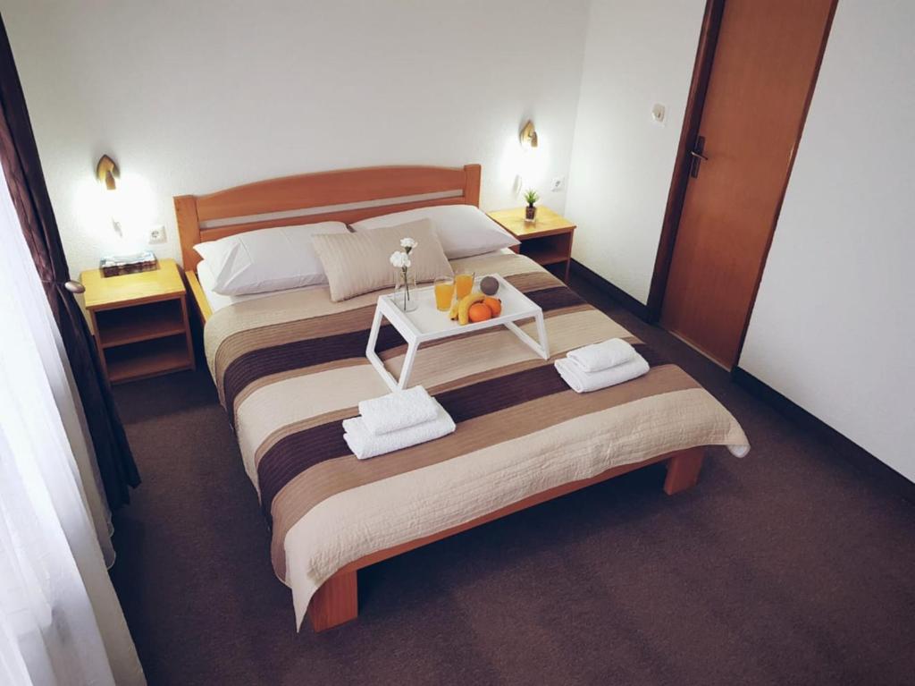1 dormitorio con 2 camas, toallas y mesa en Guesthouse Kovačević, en Korenica