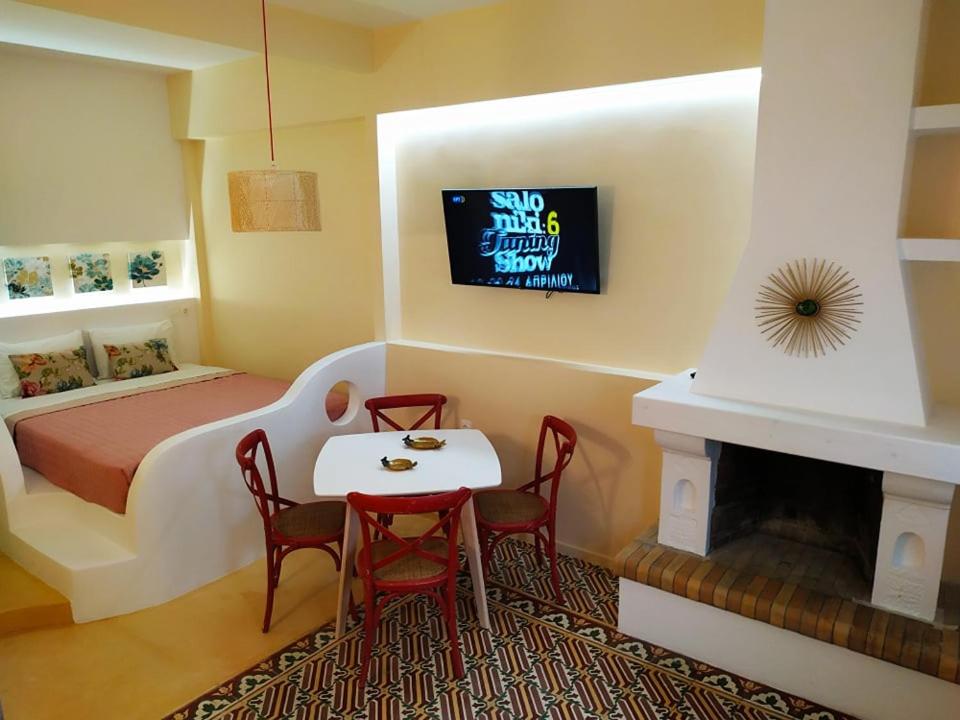 a bedroom with a bed and a table and a fireplace at Luxury studio in the centre of Palaikastro in Palekastron