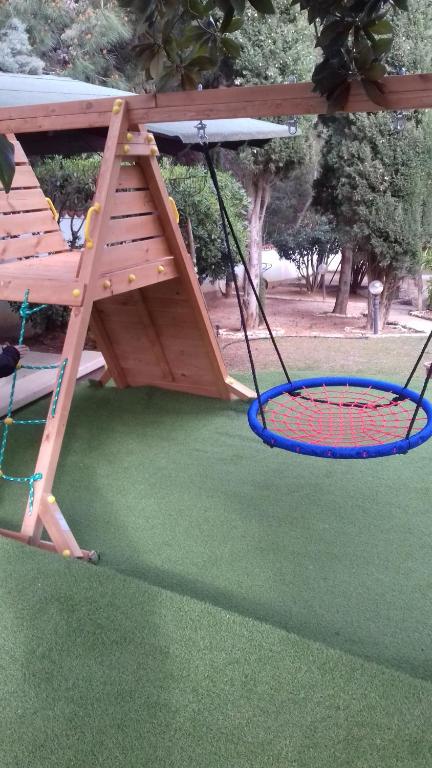 a playground with a swing and two tennis rackets at Villa Verde Apartments and Rooms in Premantura