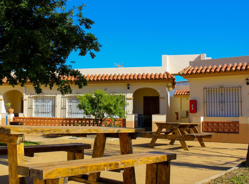 a group of picnic tables in front of a building at Apartamentos Bellavista Bolonia in Bolonia