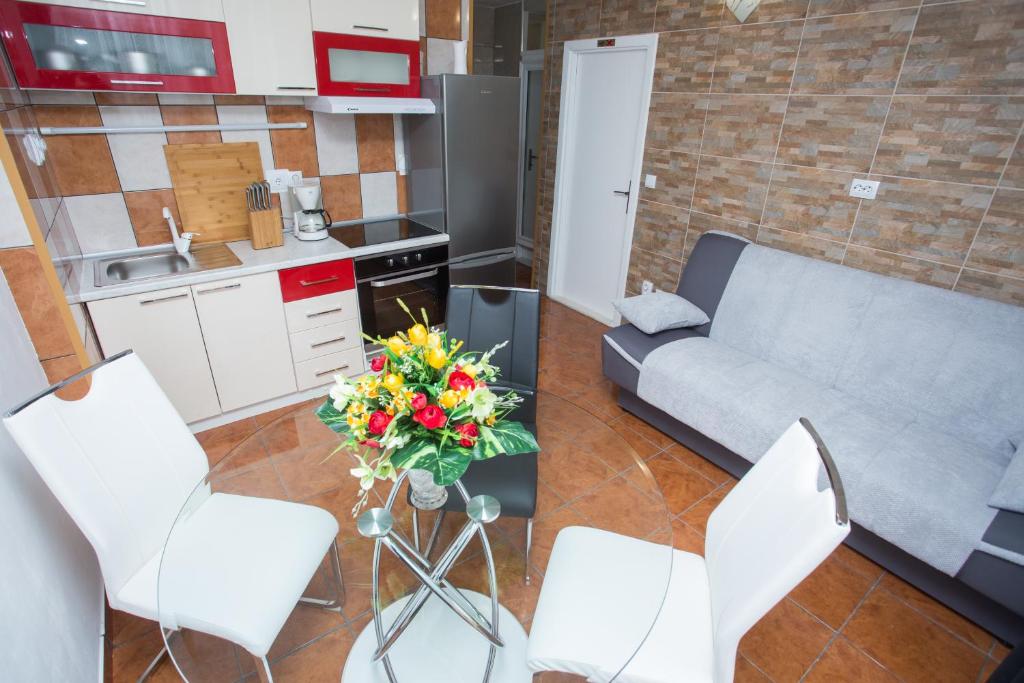 uma sala de estar com um sofá e uma mesa com flores em Apartmani Maras em Split
