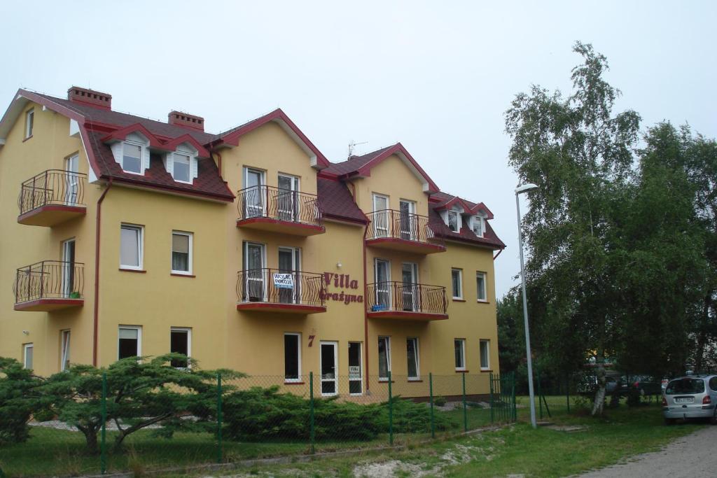 a yellow building with balconies on the side of it at willa grazyna in Dźwirzyno