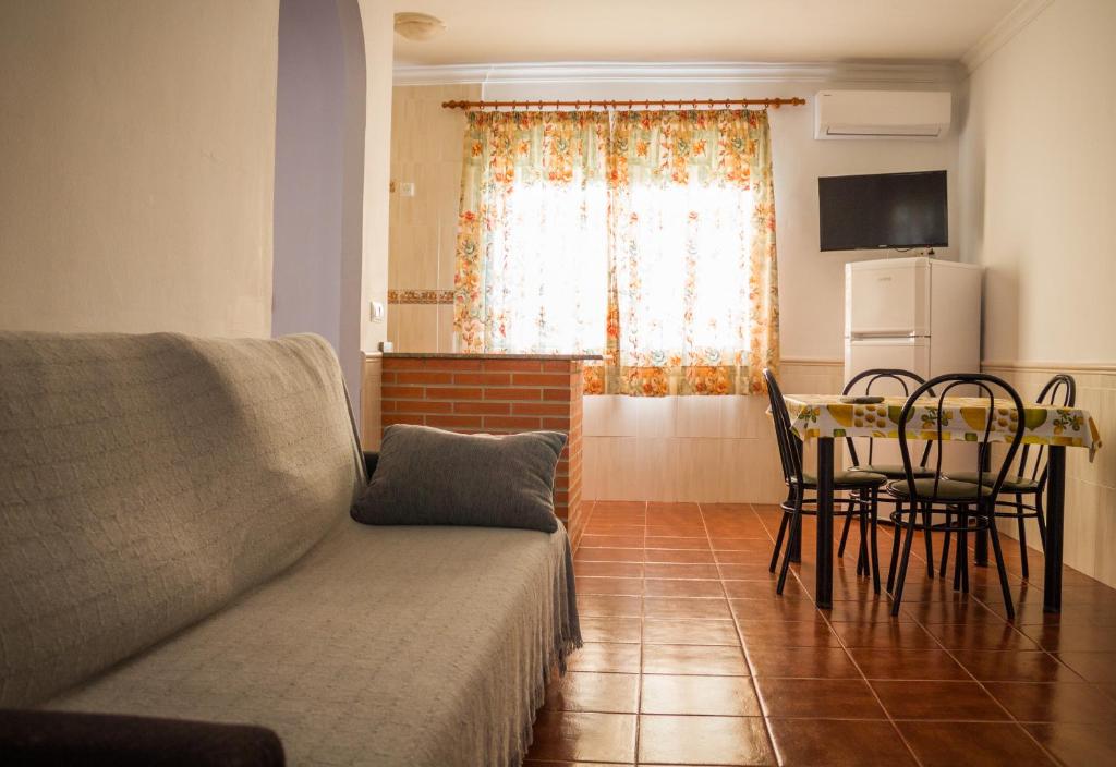 a living room with a couch and a table with chairs at Apartamentos Bellavista Bolonia in Bolonia