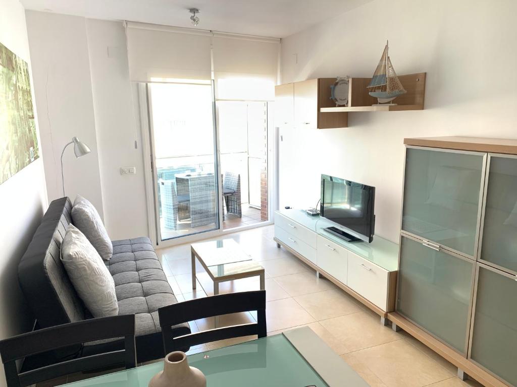 a living room with a couch and a tv at Apartamento Calafell playa in Calafell