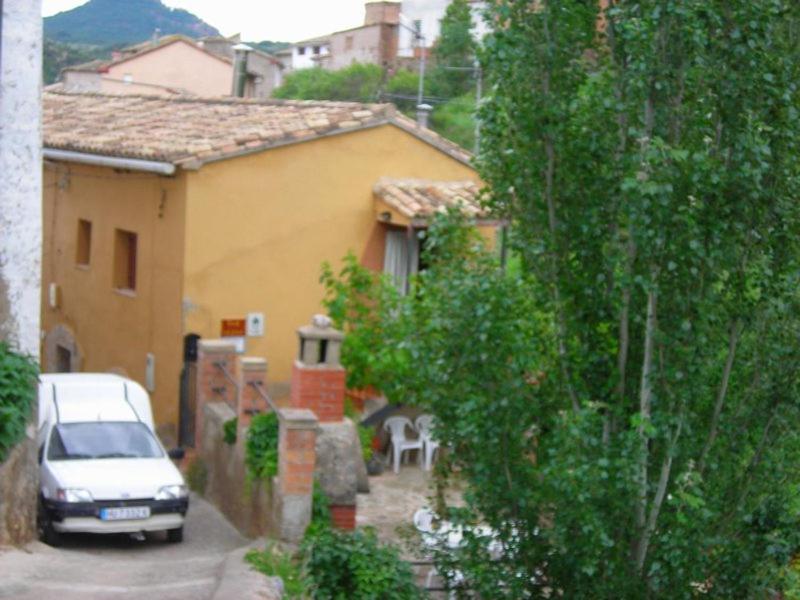 a car parked in front of a yellow house at Casa frari in Peralta de la Sal