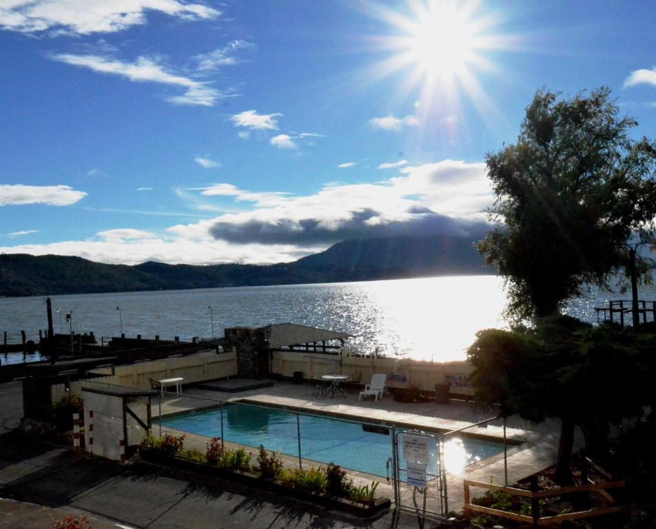 a swimming pool in front of a large body of water at Lamplighter Motel Clearlake in Clearlake