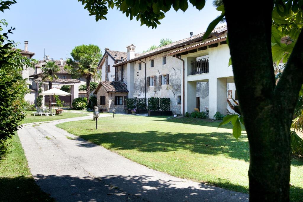 una gran casa blanca con un patio de césped en Ca' Marisa Aquileia en Aquiléia