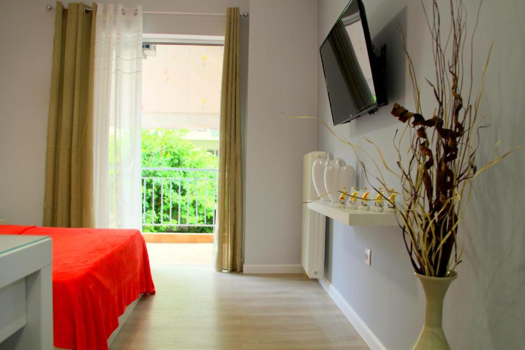 a bedroom with a red bed and a window at Studio NATASHA in the area of Kallithea in Athens
