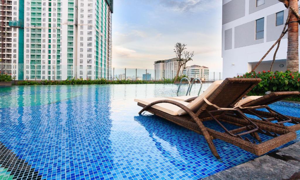 un par de sillas sentadas junto a una piscina en Goby home in Rivergate Luxury Apartment - near Ben Thanh market, en Ho Chi Minh