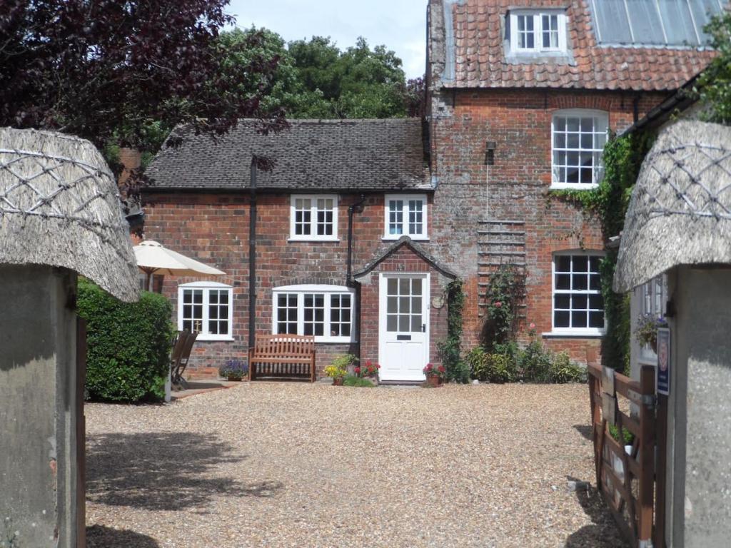 a large brick house with a white door at Stunning 3 bedroom self catering cottage near Stonehenge, Salisbury, Avebury and Bath All bedrooms ensuite in Pewsey