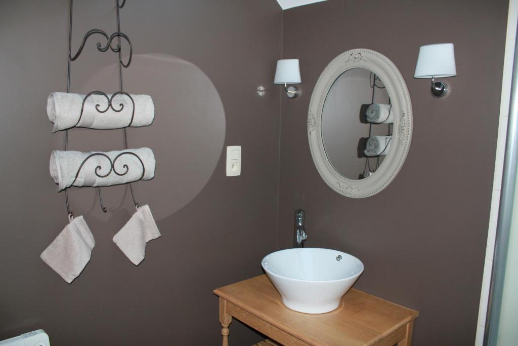 Fernelmont的住宿－A l'ombre du noyer，浴室配有盥洗盆、镜子和毛巾