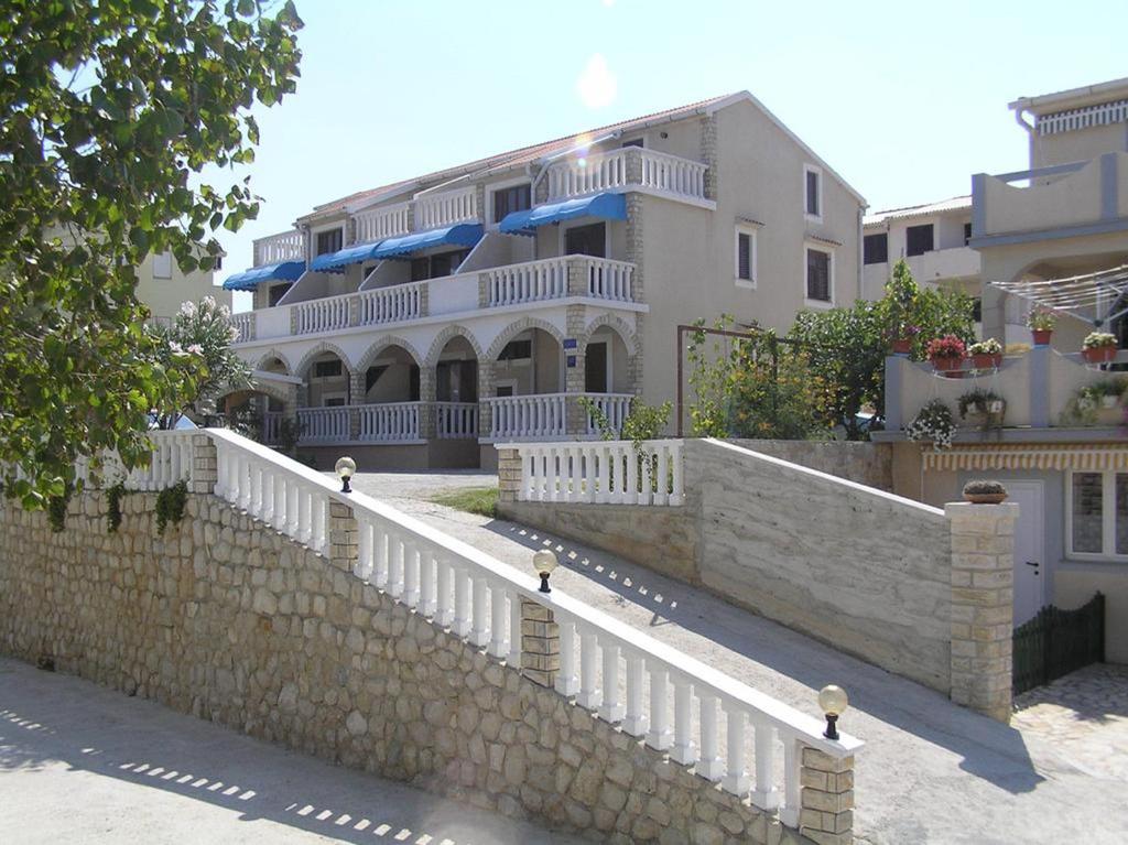 帕島的住宿－Apartments Vozab，房屋前的白色围栏