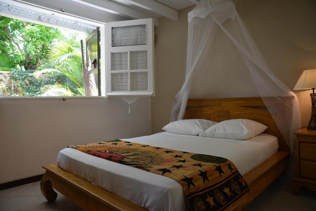 1 dormitorio con 1 cama con ventana y 1 cama sidx sidx sidx sidx en T3 Duplex Meublé Lagon Réunion, en La Saline-Les-Bains