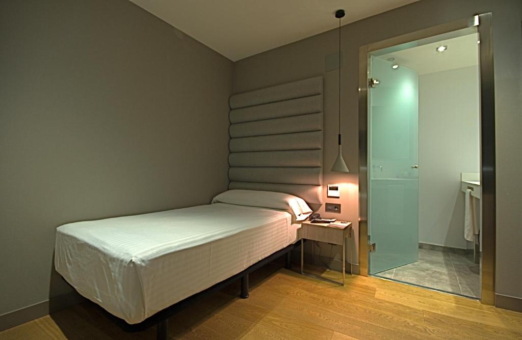 a small bedroom with a bed and a mirror at Zenit Vigo in Vigo