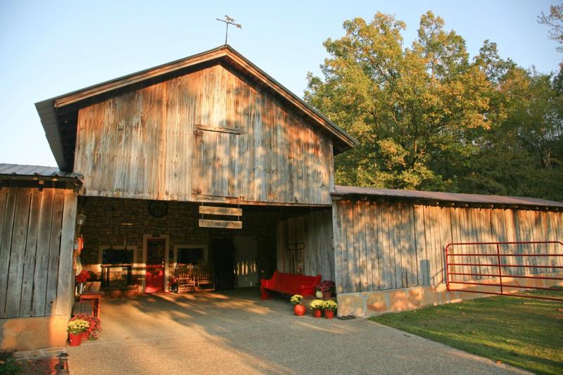 an old barn with a red couch in front of it at Panther Valley Ranch in Morning Star