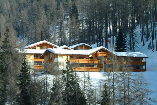 ein großes Gebäude mit Schnee darüber in der Unterkunft Case Vacanze Gli Scoiattoli in Madesimo