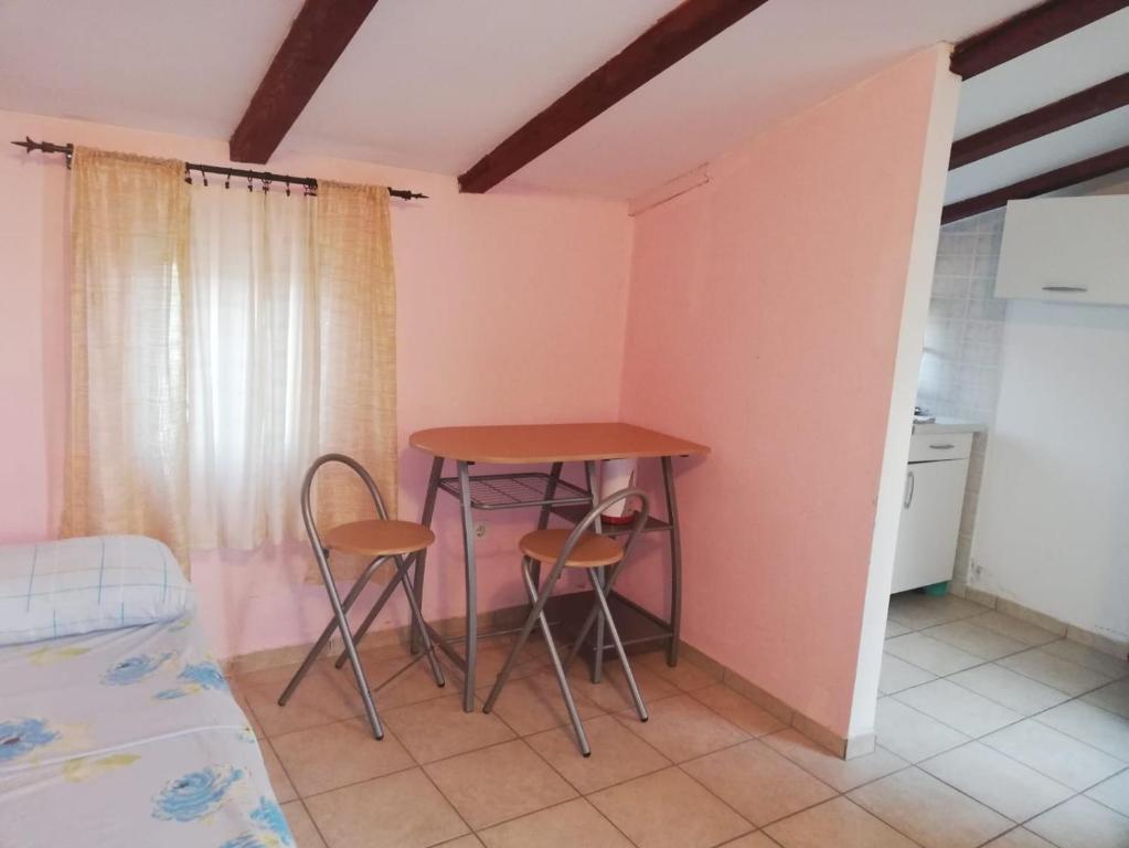 a kitchen with a table and two chairs in a room at Apartments Kleo in Orebić