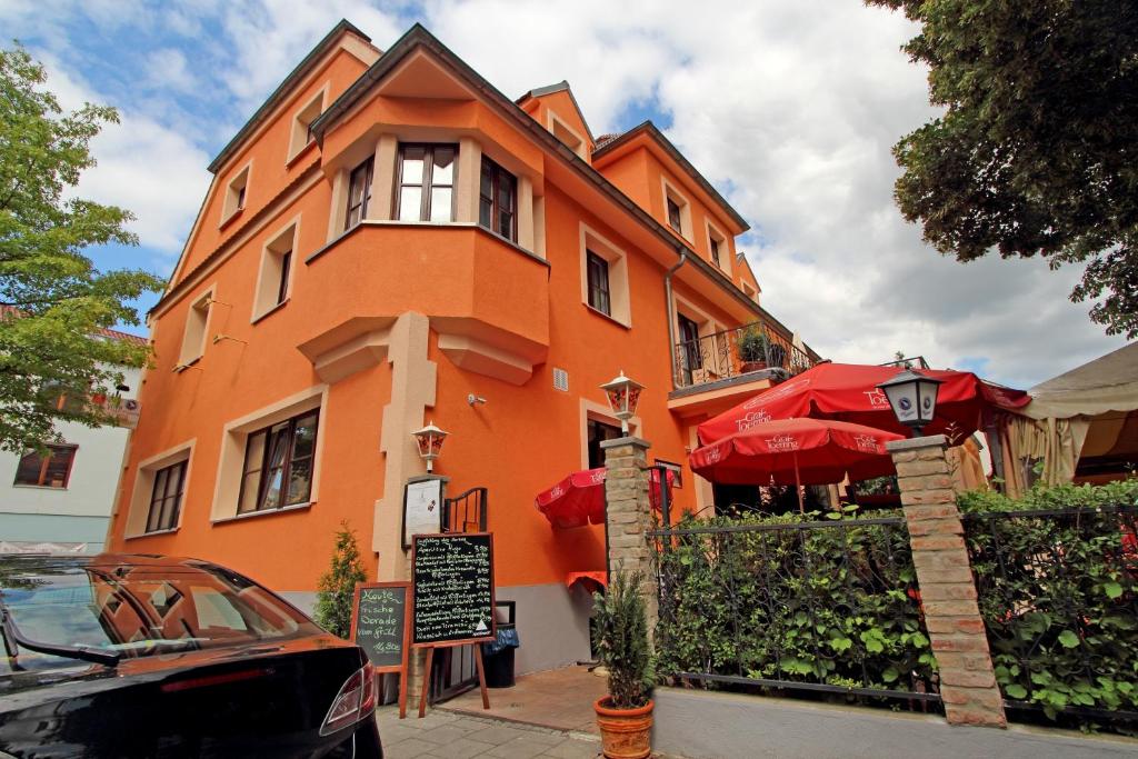 een oranje gebouw met een paraplu ervoor bij Hotel Villa Toscana in Gersthofen