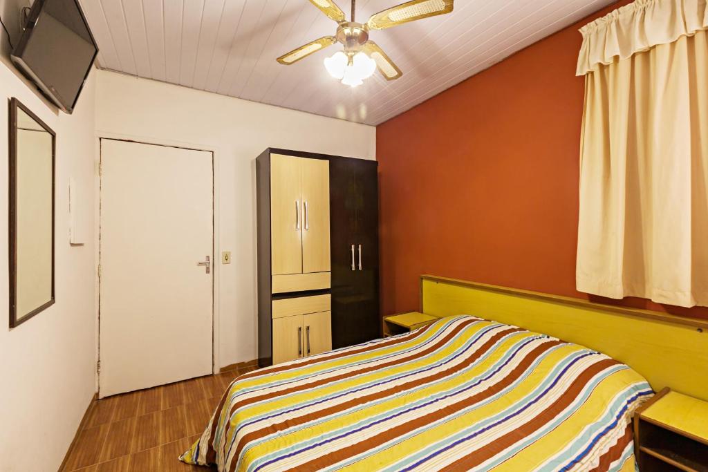 een slaapkamer met een bed en een plafondventilator bij Hotel São Paulo in Sao Paulo