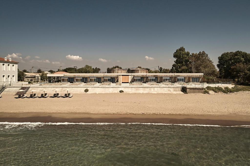 una playa con sillas y un edificio de fondo en Dexamenes Seaside Hotel, en Kourouta