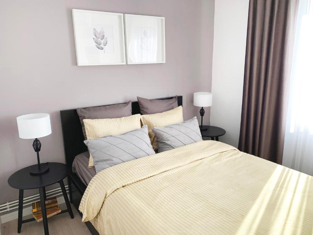 a bedroom with a bed and two tables with lamps at MHC Quiet Deluxe Suite near Downtown - Free Parking in Braşov