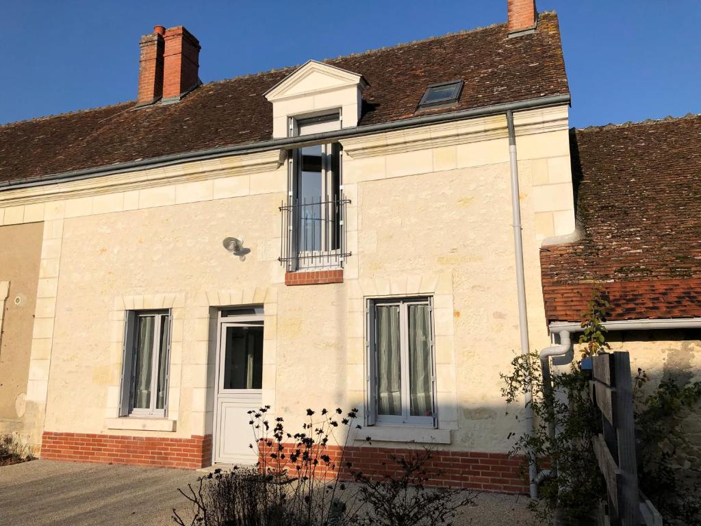 an old brick house with a white door at Gîte de la Huppe in Noyers-sur-Cher