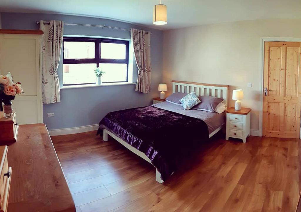 a bedroom with a large bed and a window at The Dairy Lodge in Kilmallock