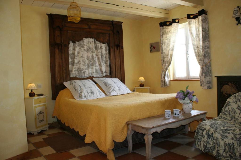 a bedroom with a large bed and a couch at B&B au petit tambour d'Autingues in Autingues
