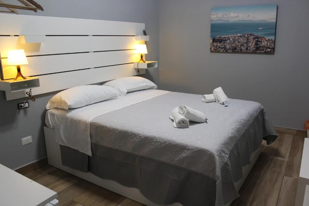 una camera da letto con un grande letto con due asciugamani di Central Station Garibaldi a Napoli