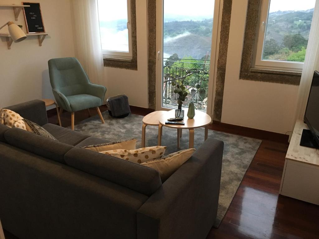 uma sala de estar com um sofá, uma mesa e uma cadeira em Casa do Giraldo - Alojamento Local em Arcos de Valdevez