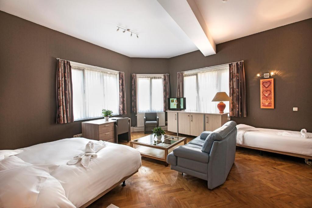 1 dormitorio con 2 camas, silla y mesa en Hotel Cathedral en Ghent