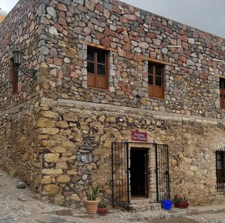 an old stone building with a door and windows at Hotel San Pancho in Real de Catorce