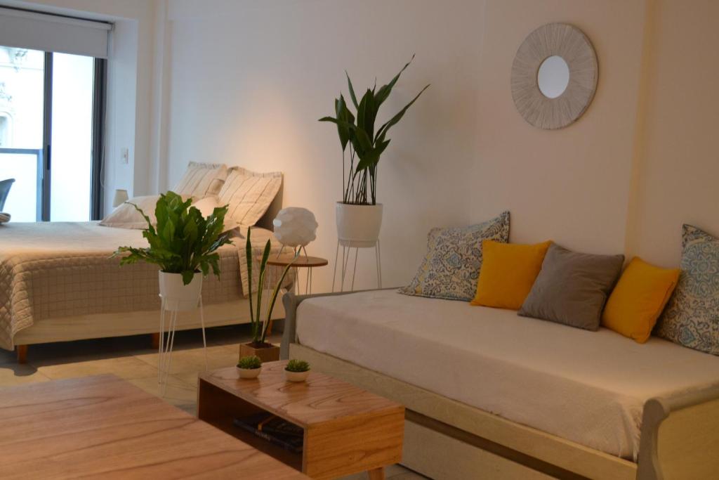 una sala de estar con un sofá y una cama en APT New Studio Palermo, en Buenos Aires