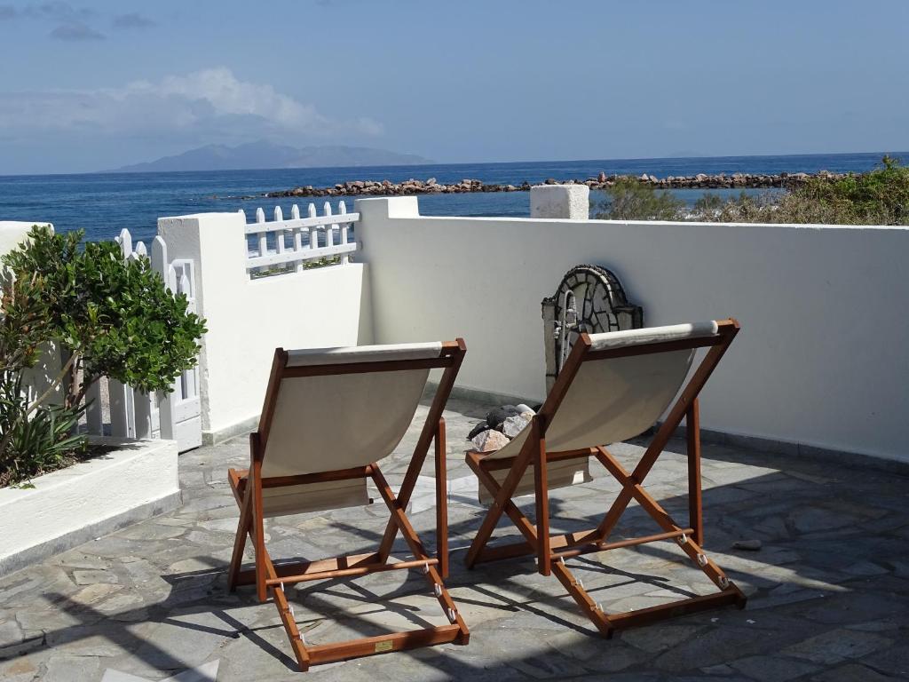 2 sillas sentadas en un patio con vistas al océano en NAMA Beach house en Monolithos