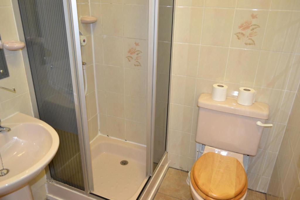 a bathroom with a shower and a toilet and a sink at Croft Hotel in Leicester