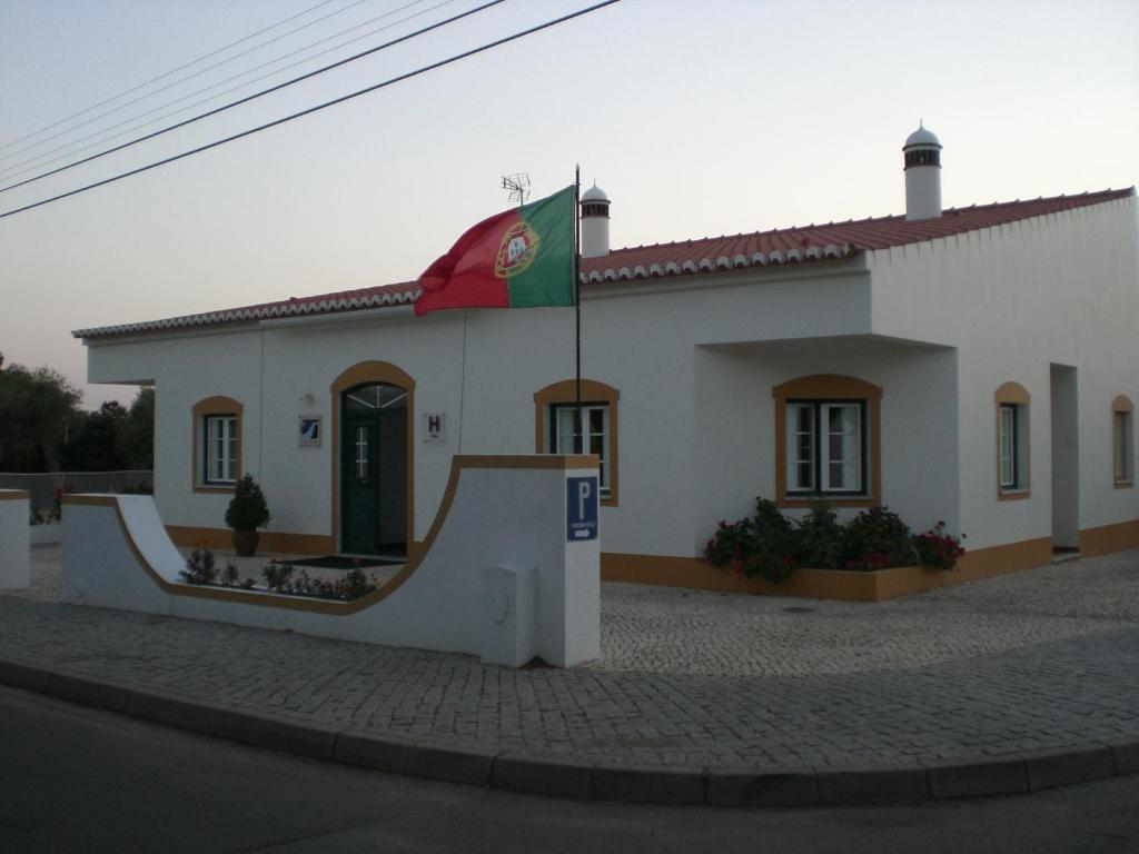 um edifício com uma bandeira à sua frente em Hotel Pulo do Lobo em Serpa