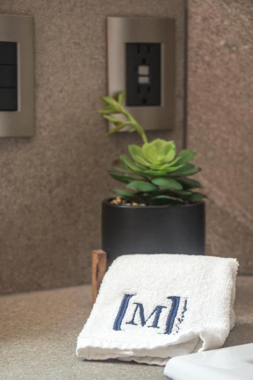 a white towel on a table with a potted plant at Maja Hotel Boutique in Morelia