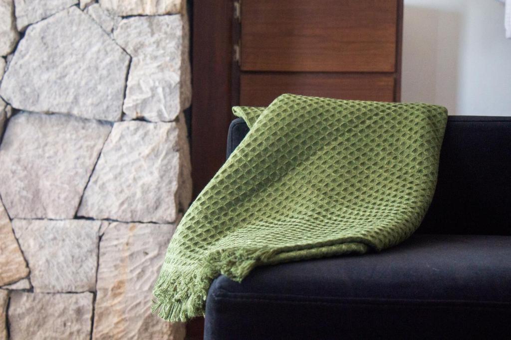 a green pillow sitting on a couch next to a stone wall at Maja Hotel Boutique in Morelia