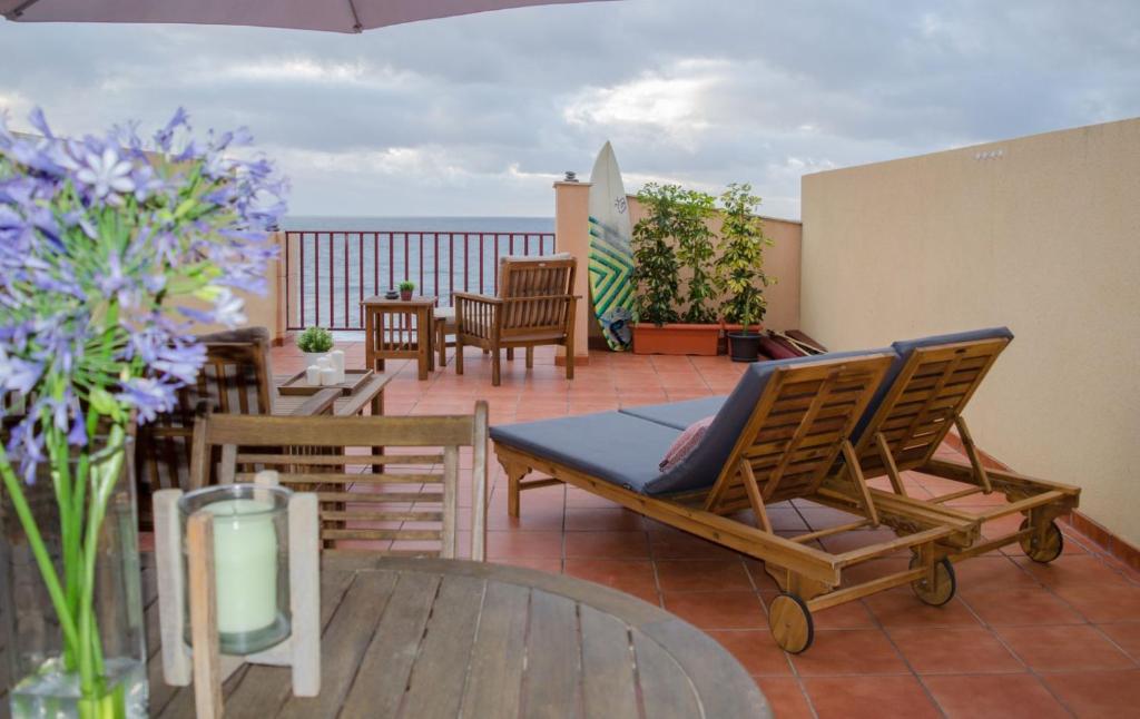 Un patio con sillas y una mesa en el balcón. en LivingtheOcean & Big Terrace, en Santa María de Guía de Gran Canaria