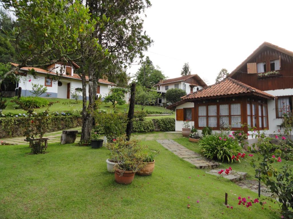 uma casa com um quintal com vasos de plantas em Chalés Recanto Pássaros em Monte Verde