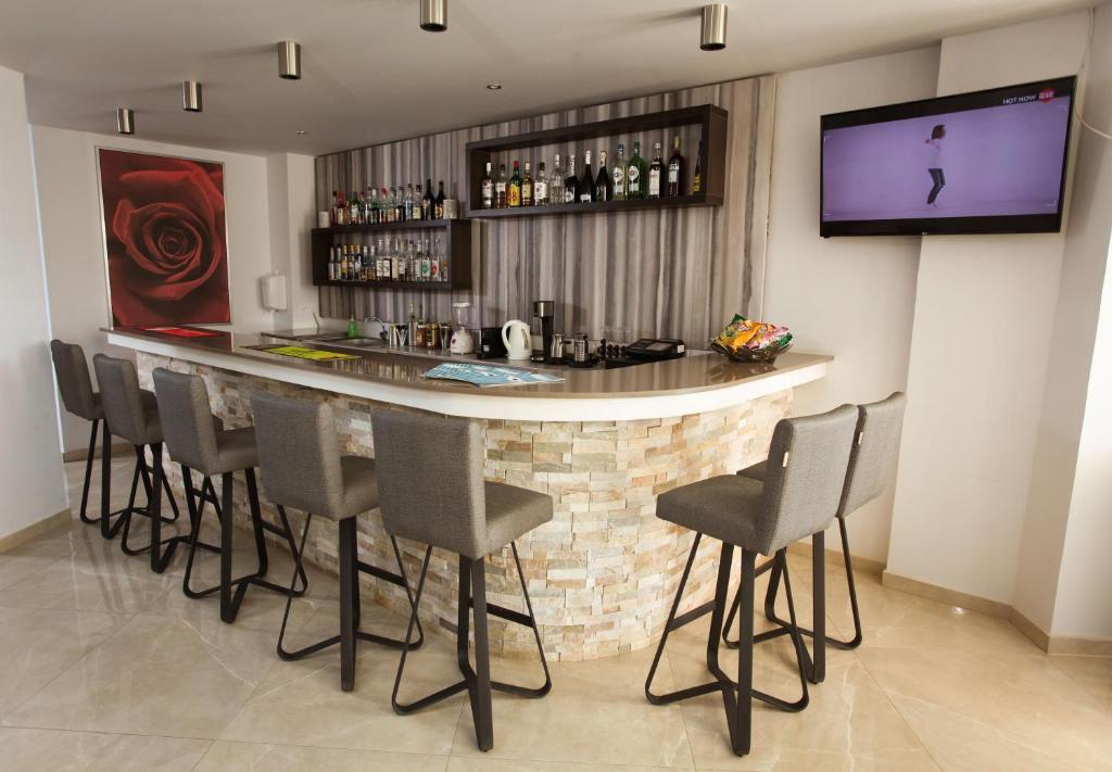a bar with chairs and a television in a room at Bellini Hotel in Ayia Napa