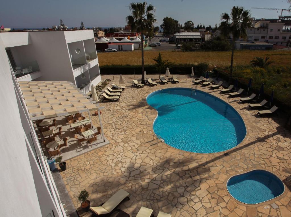 an overhead view of a large swimming pool with lounge chairs at Bellini Hotel in Ayia Napa