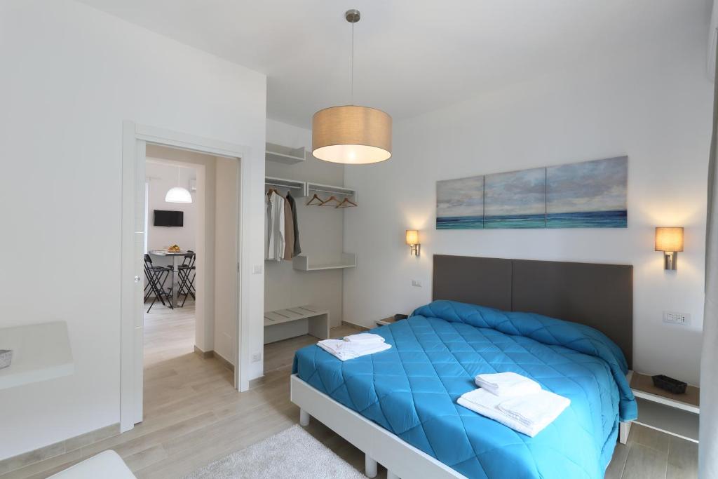 ein Schlafzimmer mit einem blauen Bett in einem Zimmer in der Unterkunft Cartolina Apartment in Taormina
