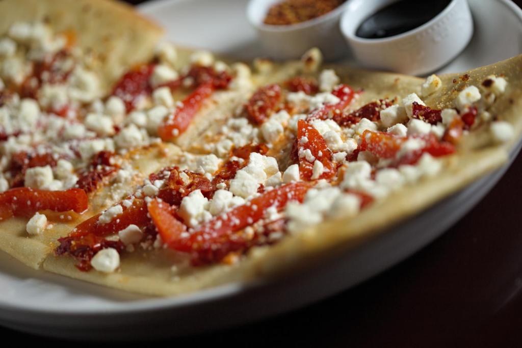 a pizza with tomatoes and cheese on a plate at Hotel Ruby in Spokane