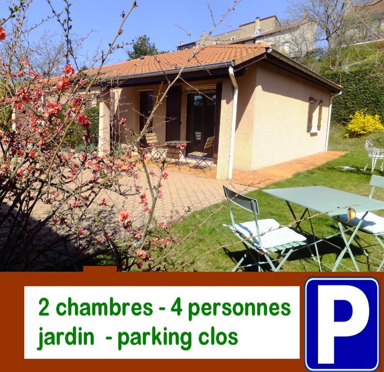 een huis met een tuin met een tafel en stoelen bij Le Clos Gentiane in Saint-Étienne
