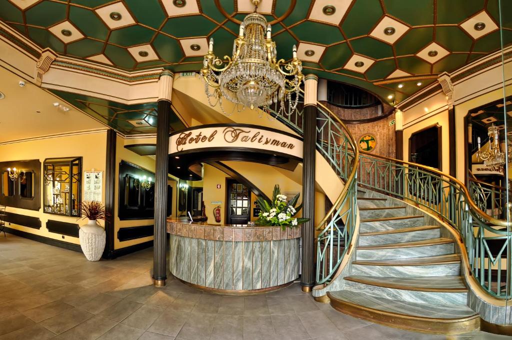 a spiral staircase in a building with a chandelier at Hotel Talisman in Ponta Delgada